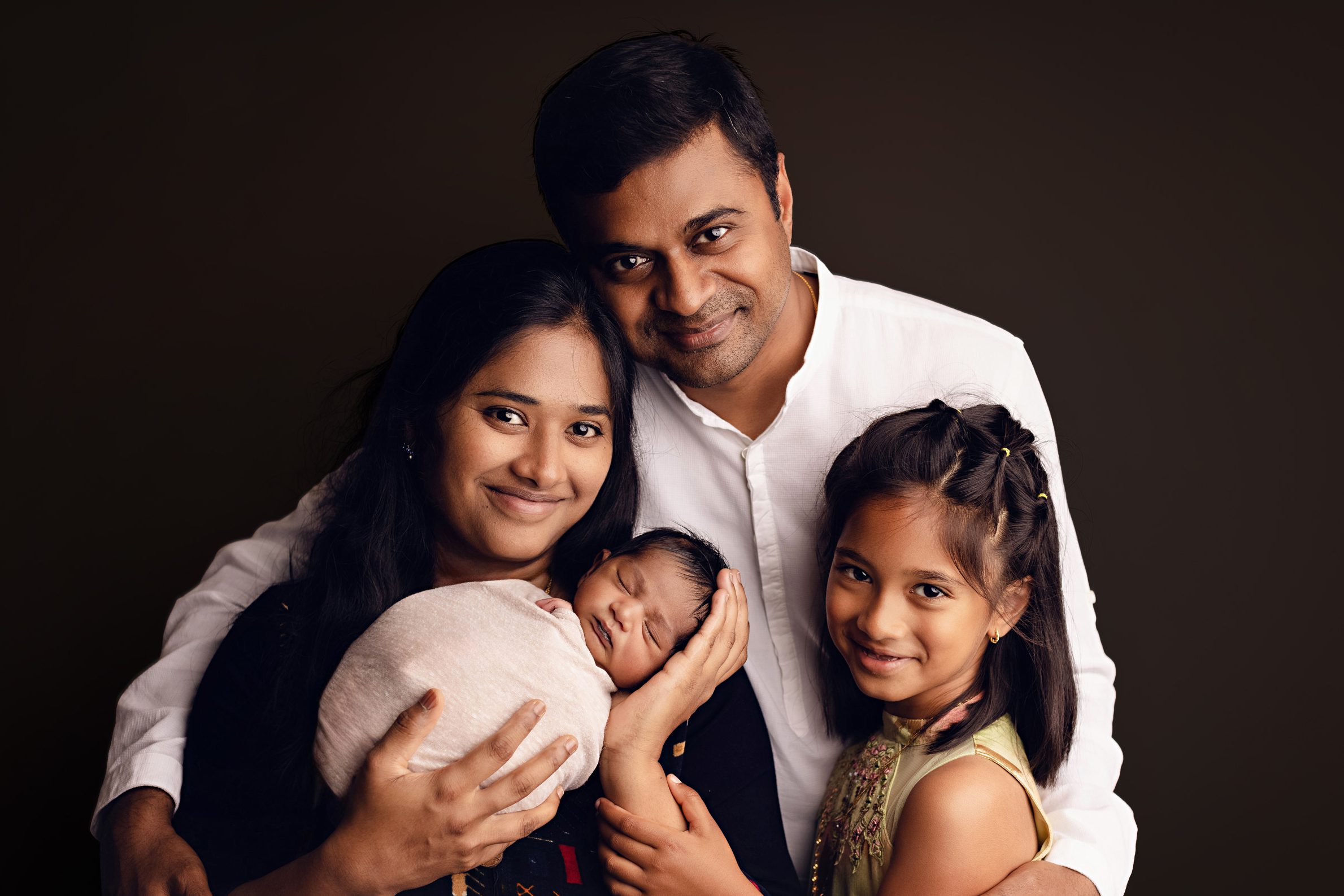 Family of four with newborn baby during a studio portrait session.