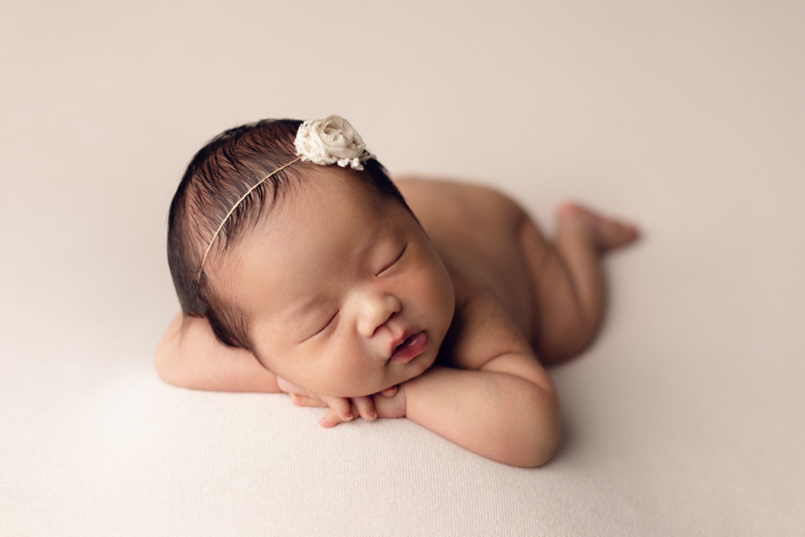 Sleeping newborn baby posed on hands during a professional newborn photography session