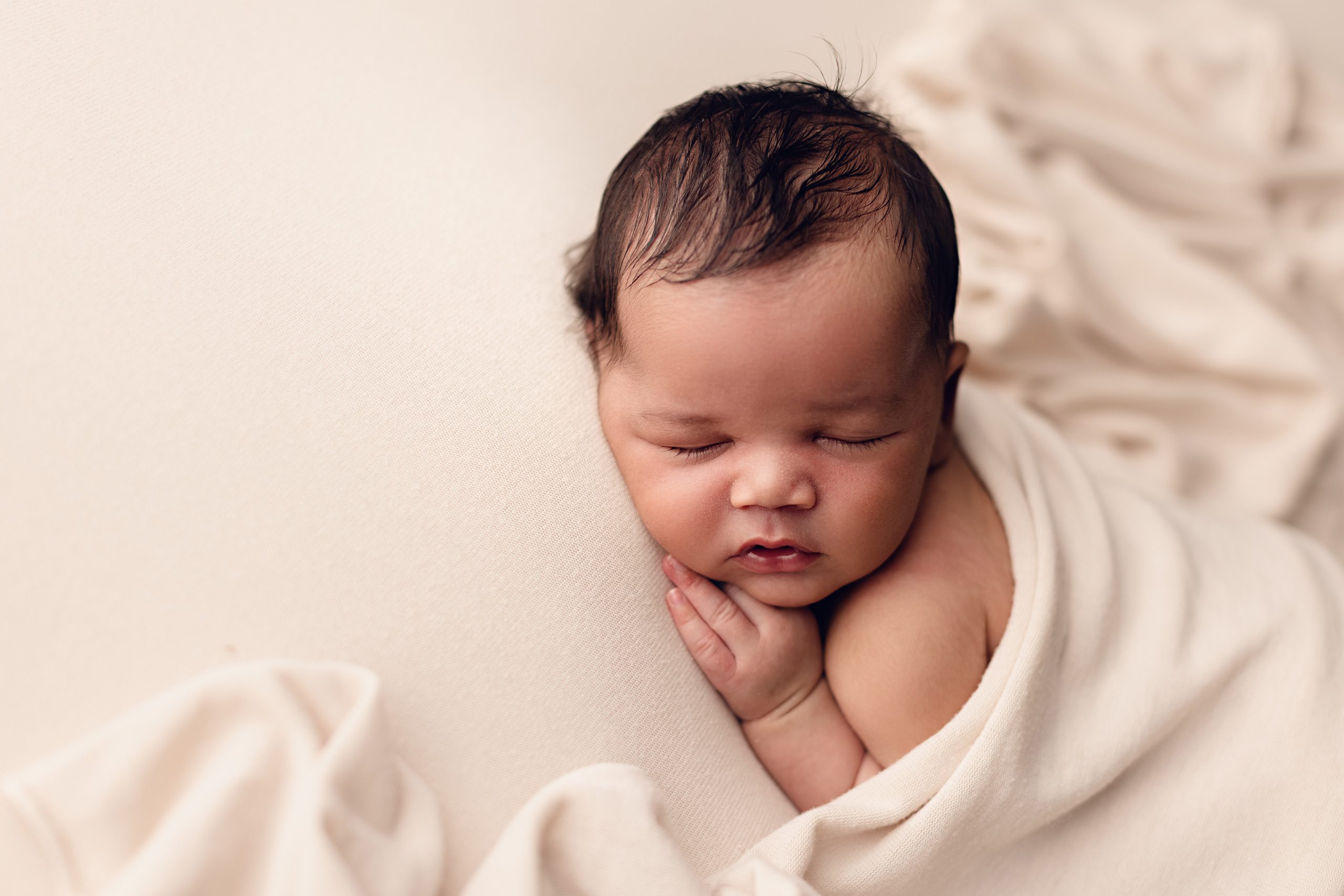 Sleeping wrapped newborn baby photographed in a Minnesota newborn photography studio.